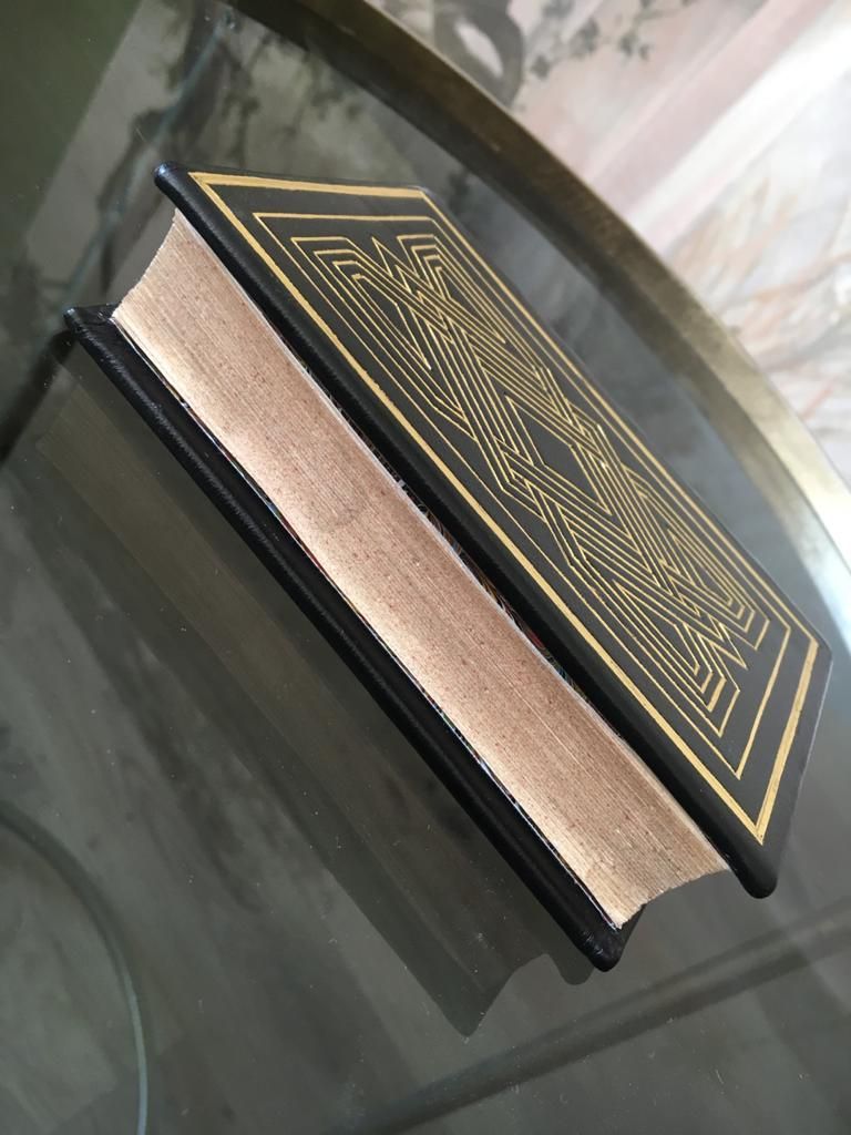 Un livre noir et or est posé sur une table en verre