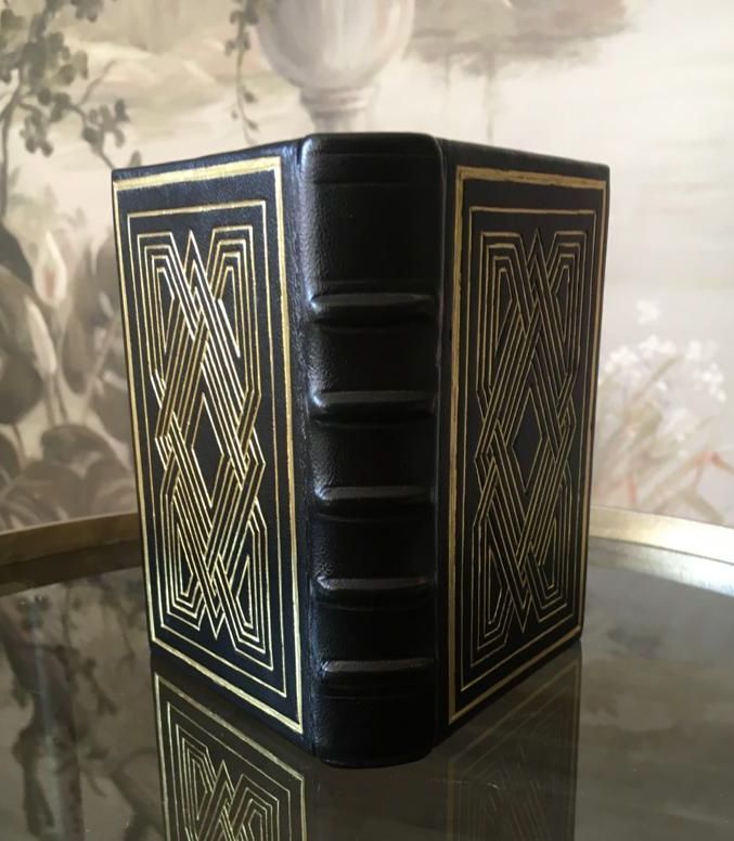 Un livre noir et or est posé sur une table en verre