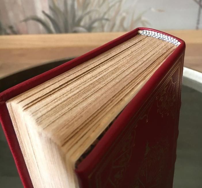Un livre avec une couverture rouge est posé sur une table
