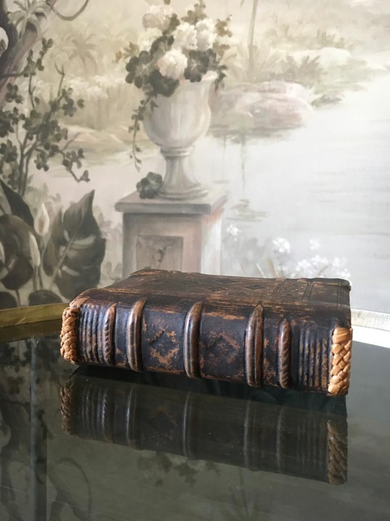 Un vieux livre est posé sur une table en verre.