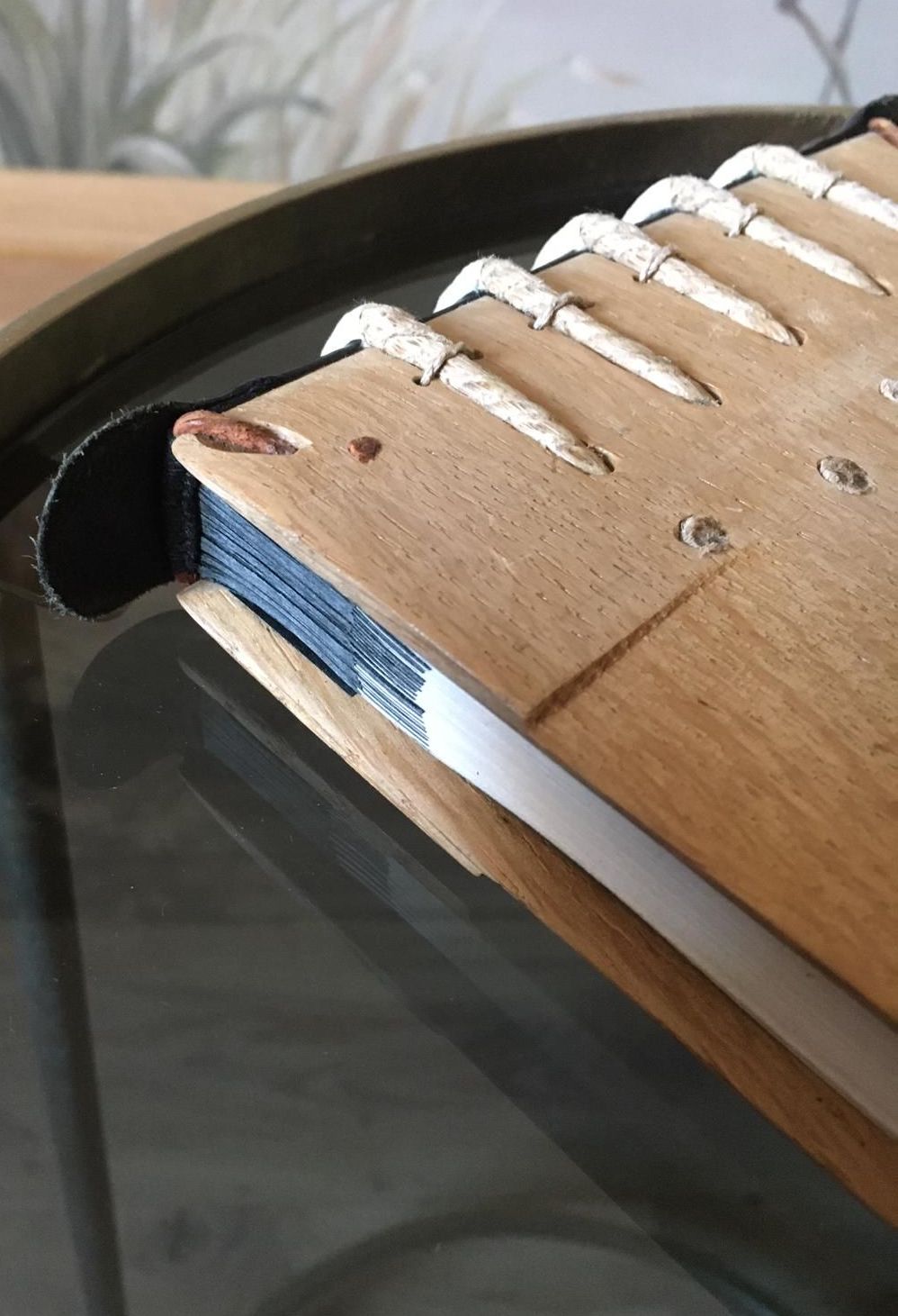 Un livre en bois est posé sur une table en verre.