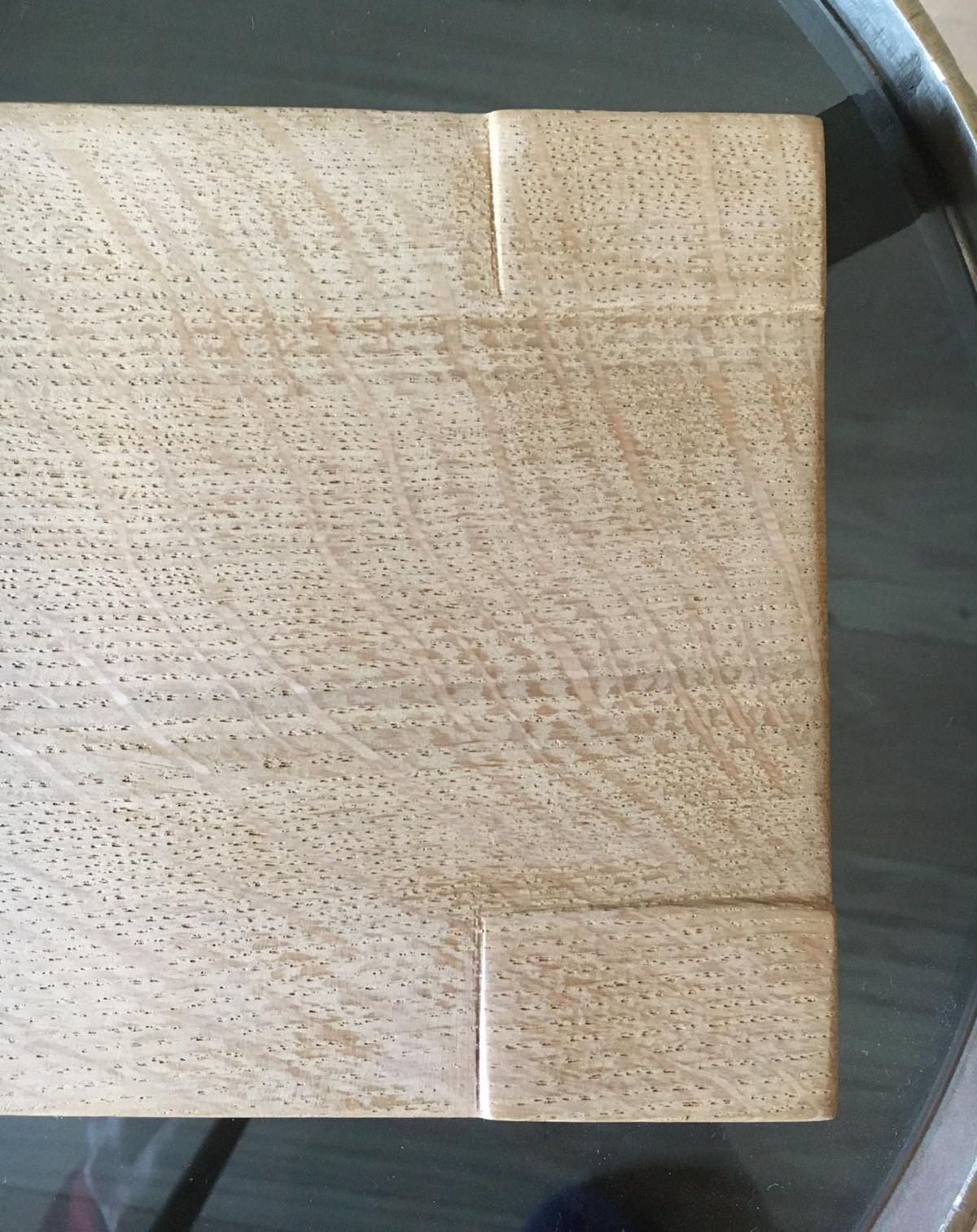 Un morceau de bois est posé sur une table en verre.