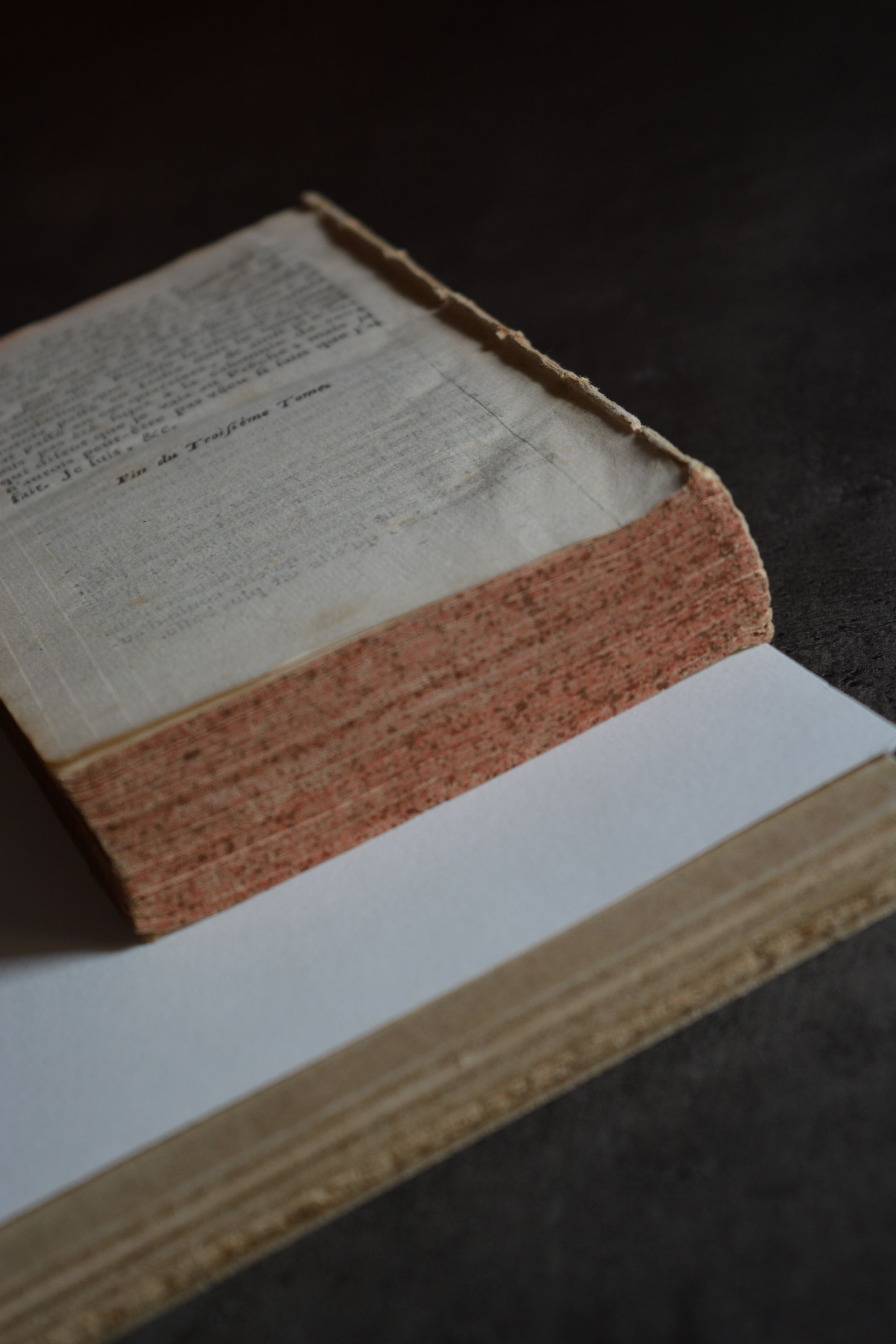 Un vieux livre est posé sur un morceau de papier