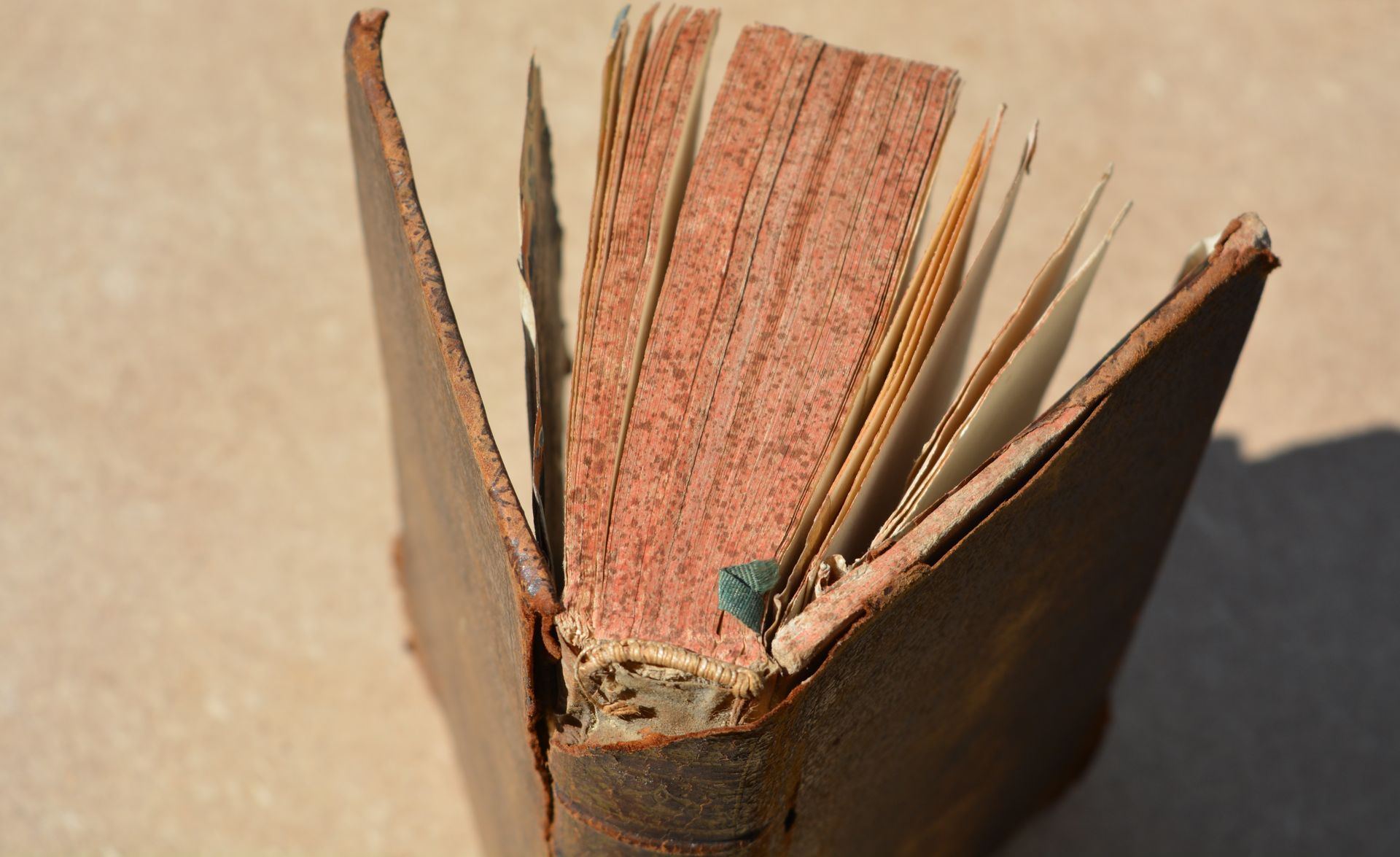Un vieux livre avec une tranche cassée est posé sur une table