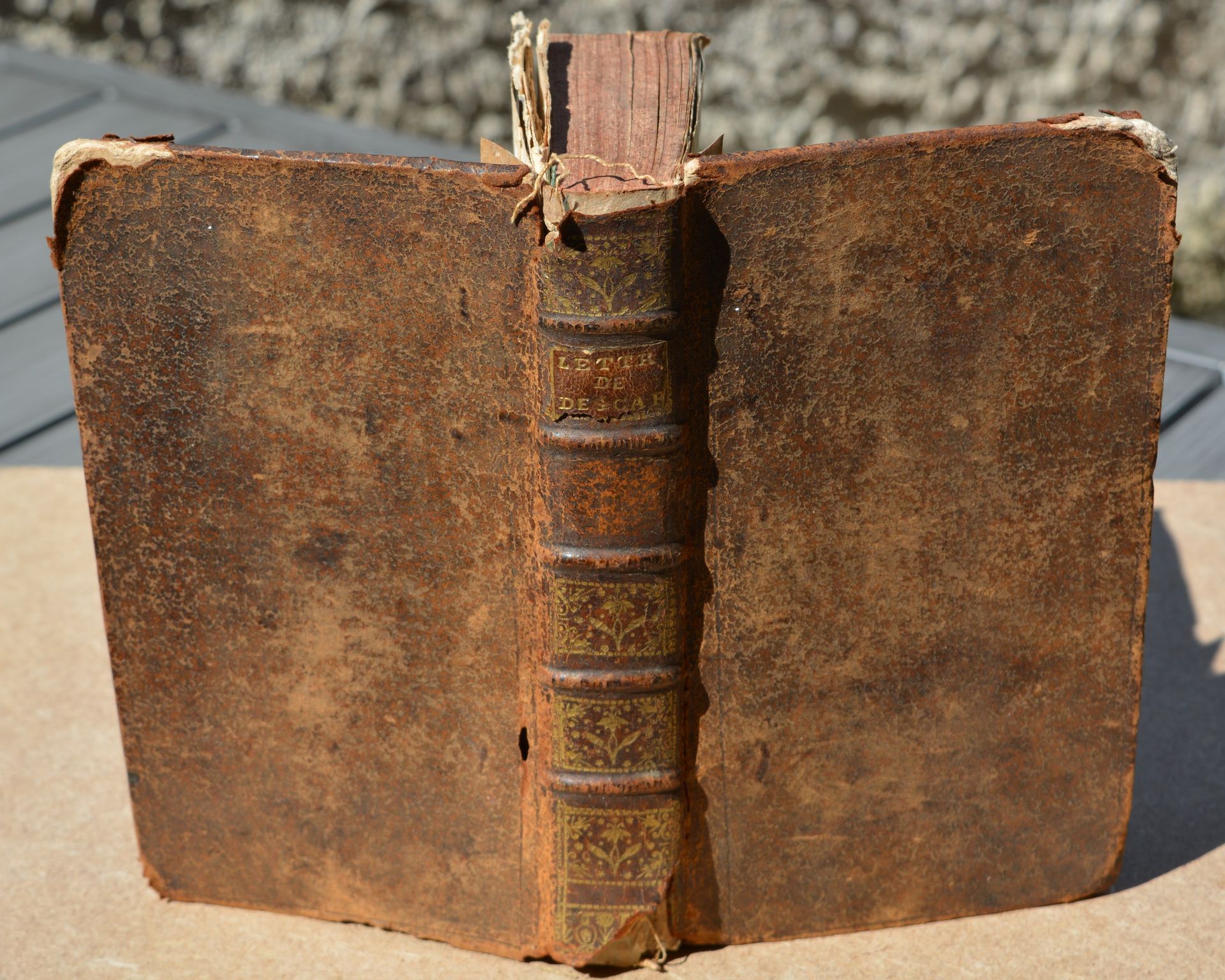 Un vieux livre avec une tranche cassée est posé sur une table