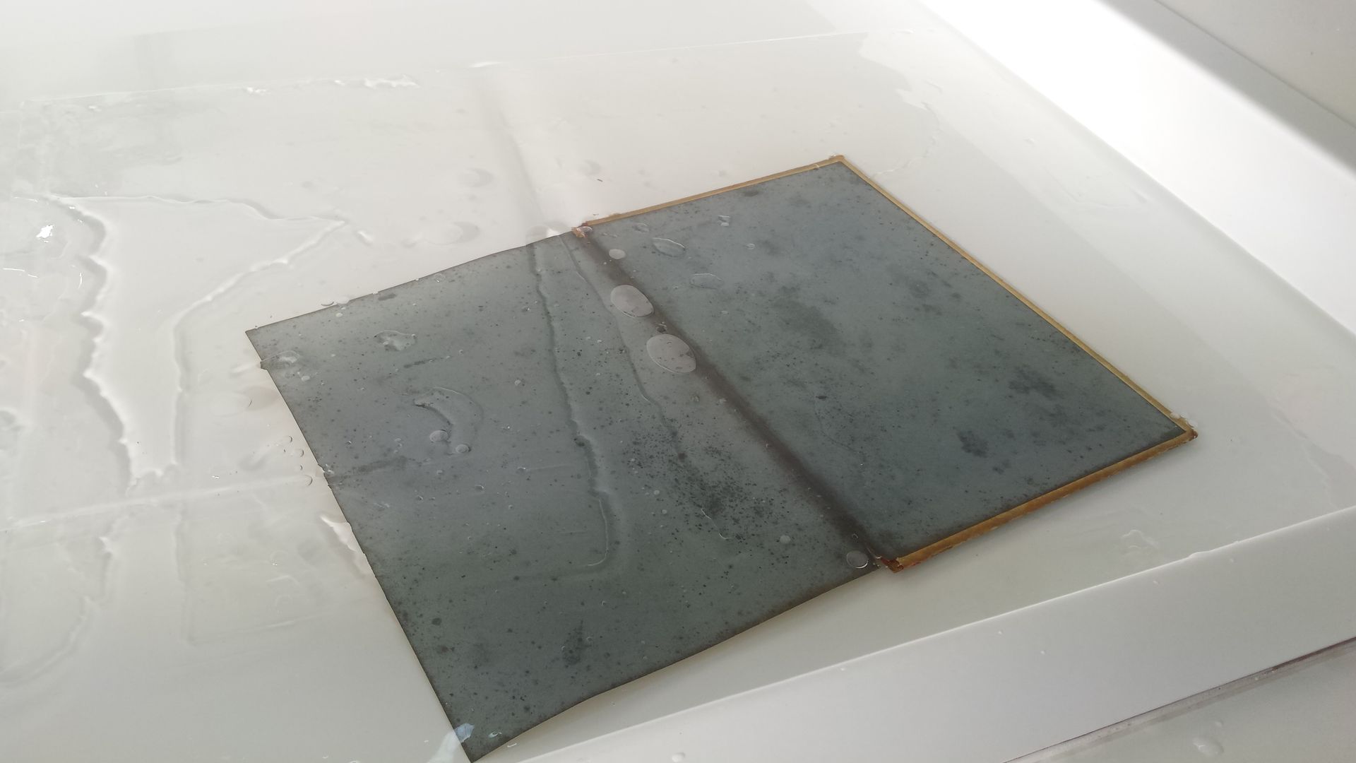 Un morceau de métal est posé sur une surface blanche.