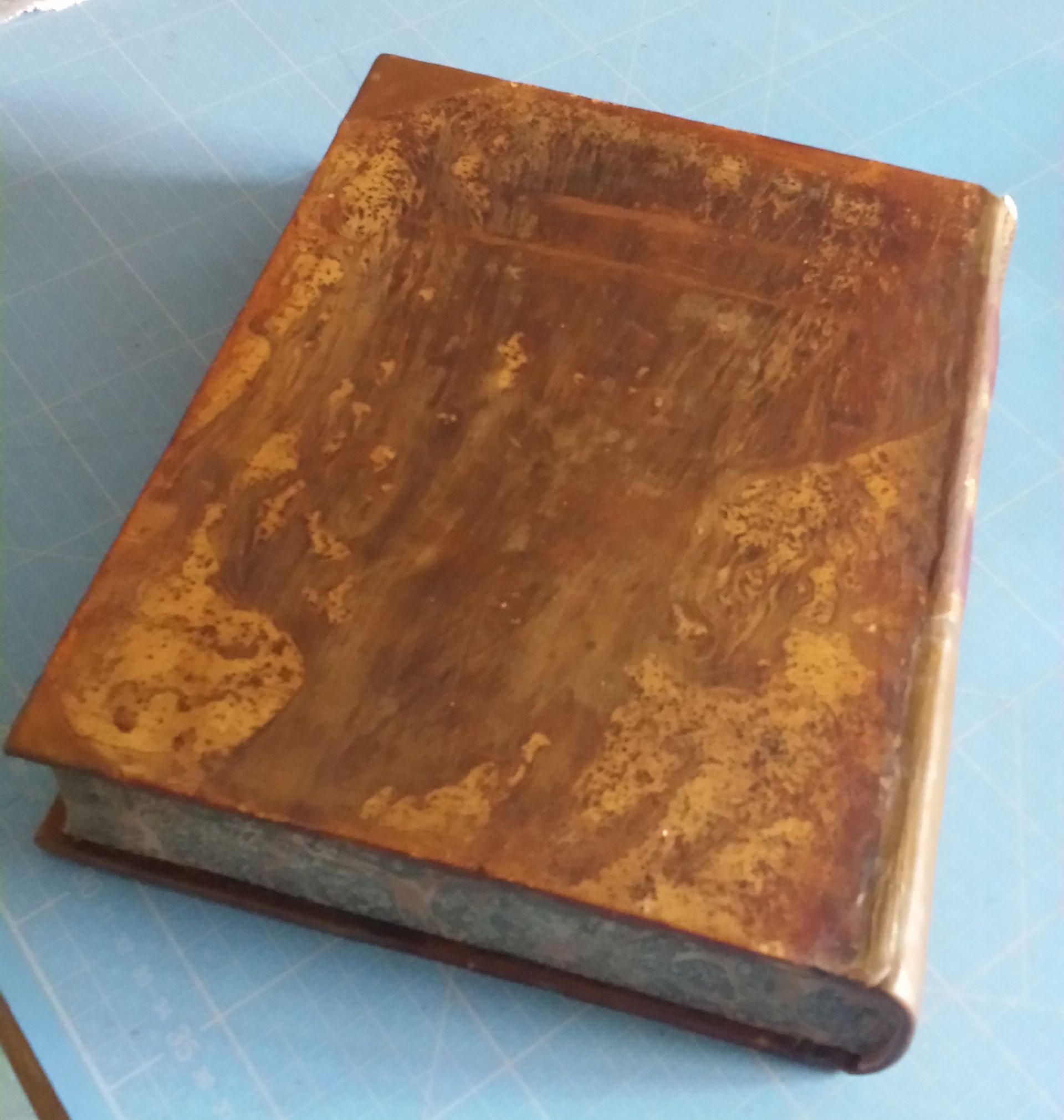 Un livre marron est posé sur une surface bleue