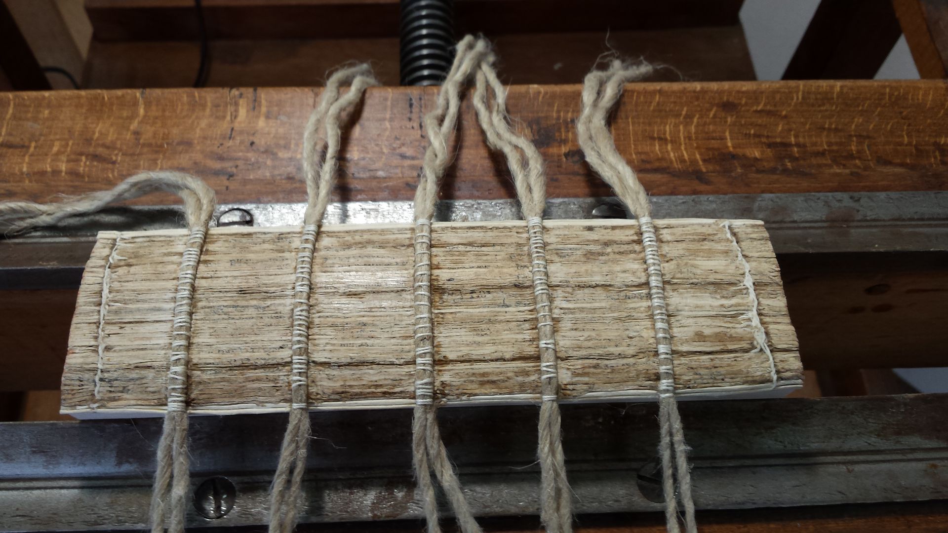 Un morceau de bois avec une corde enroulée autour est posé sur une table en bois.