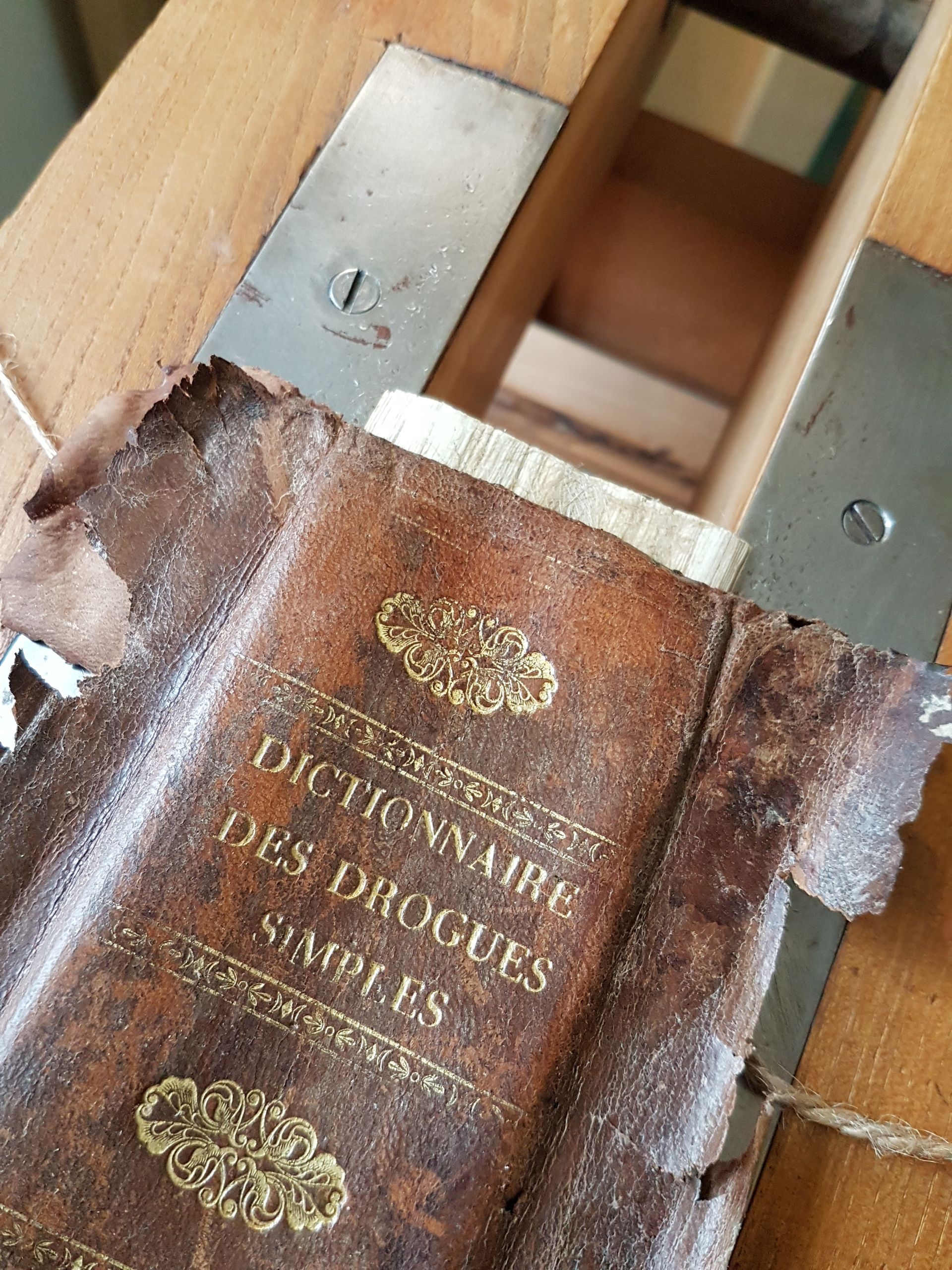 Un dictionnaire est posé sur une table en bois à côté d'une scie.