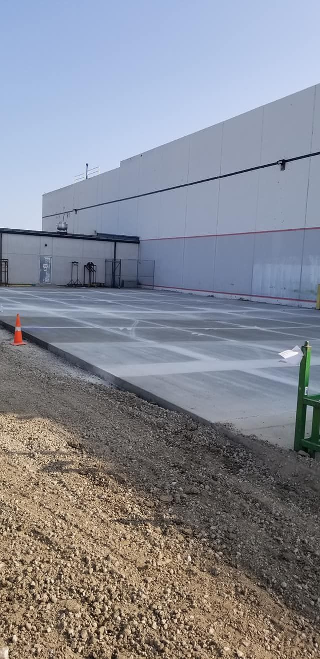 A large white building with a concrete driveway in front of it.