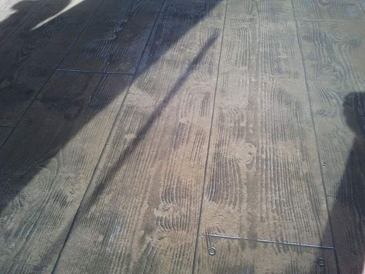 A shadow of a person is cast on a wooden floor.