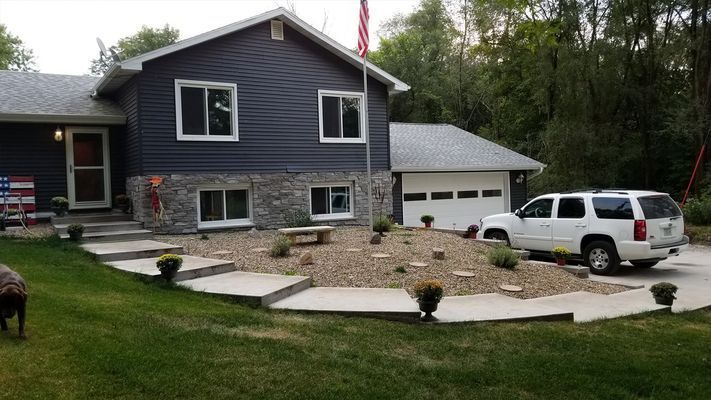 A white suv is parked in front of a large house.