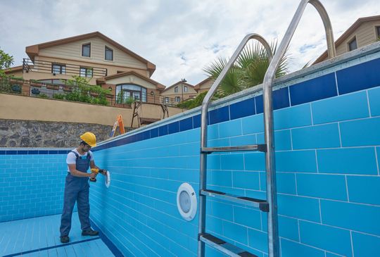 Repairman is repairing pool with equipment