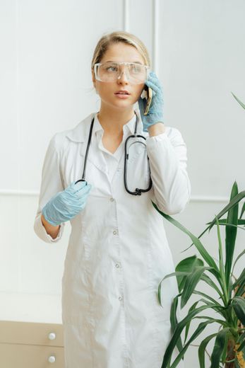 A female doctor is talking on a cell phone.