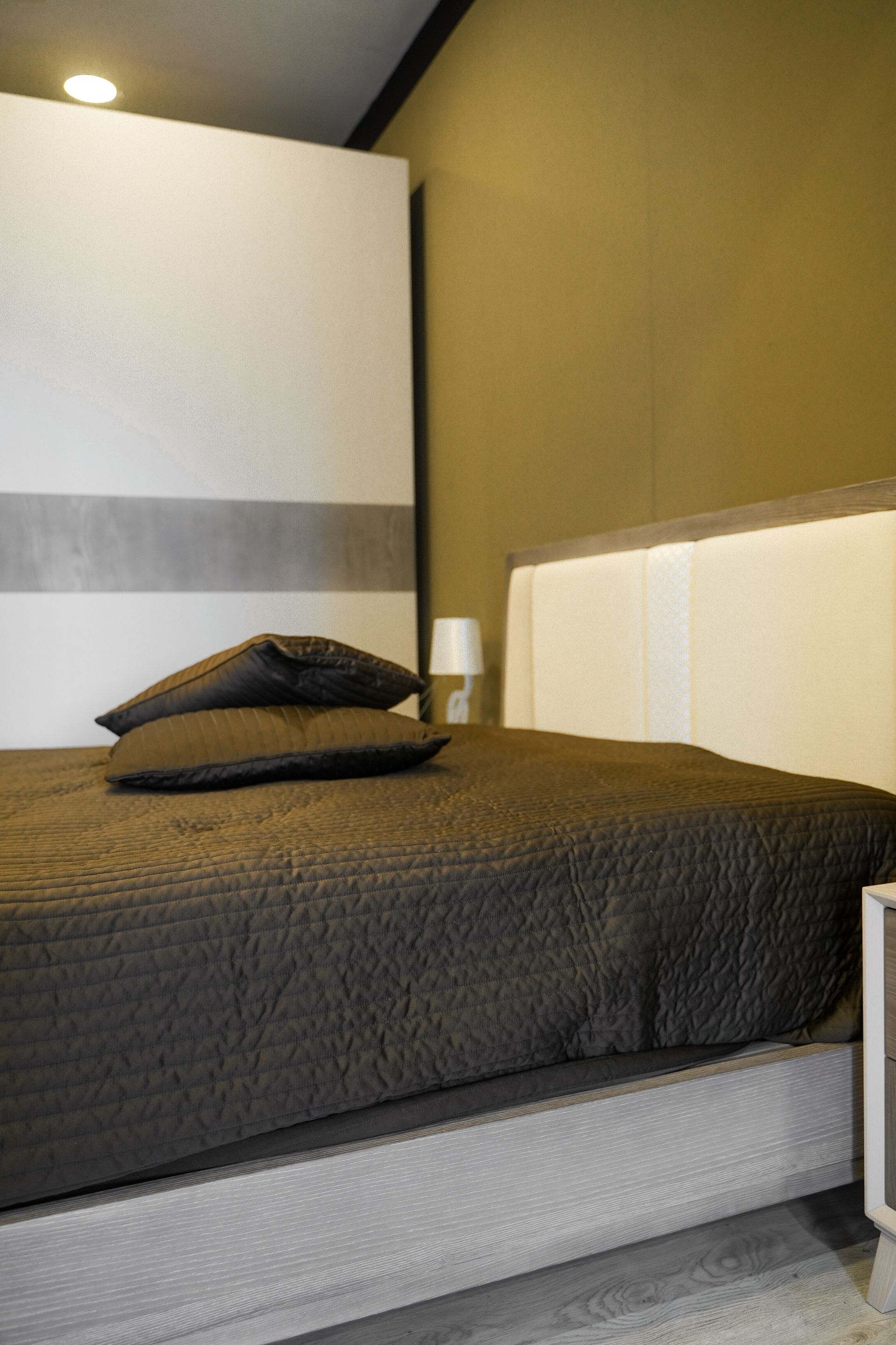 Una camera da letto con un letto, un comodino e un armadio scorrevole.