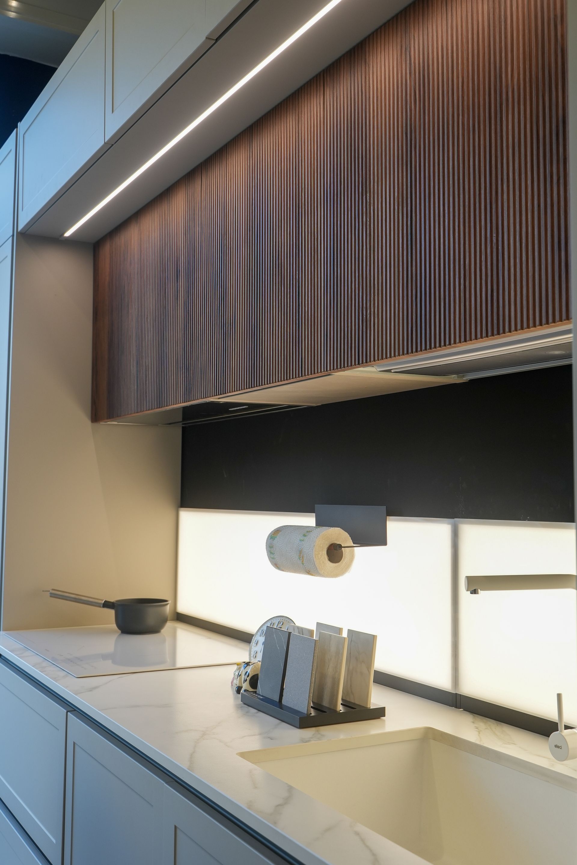 Una cucina con un lavandino e un portarotolo di carta.