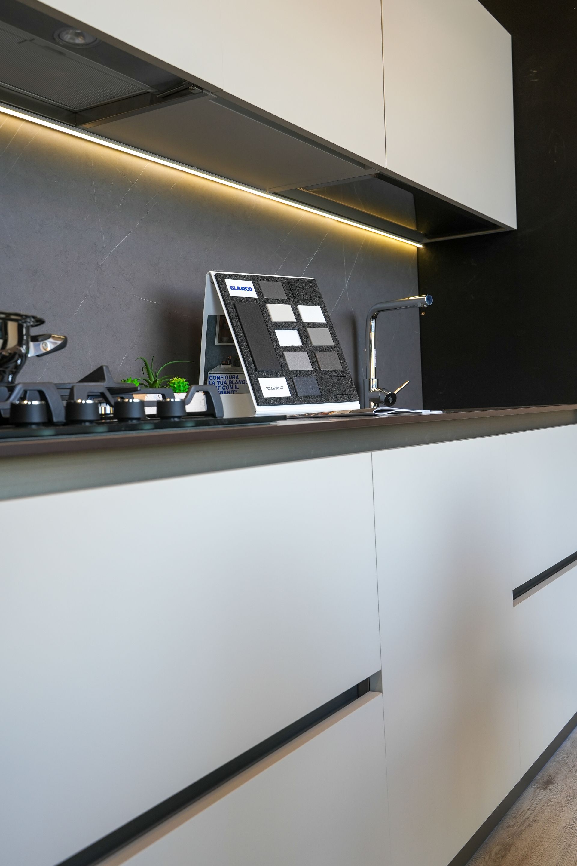 Una cucina con mobili bianchi, un lavello e un forno.