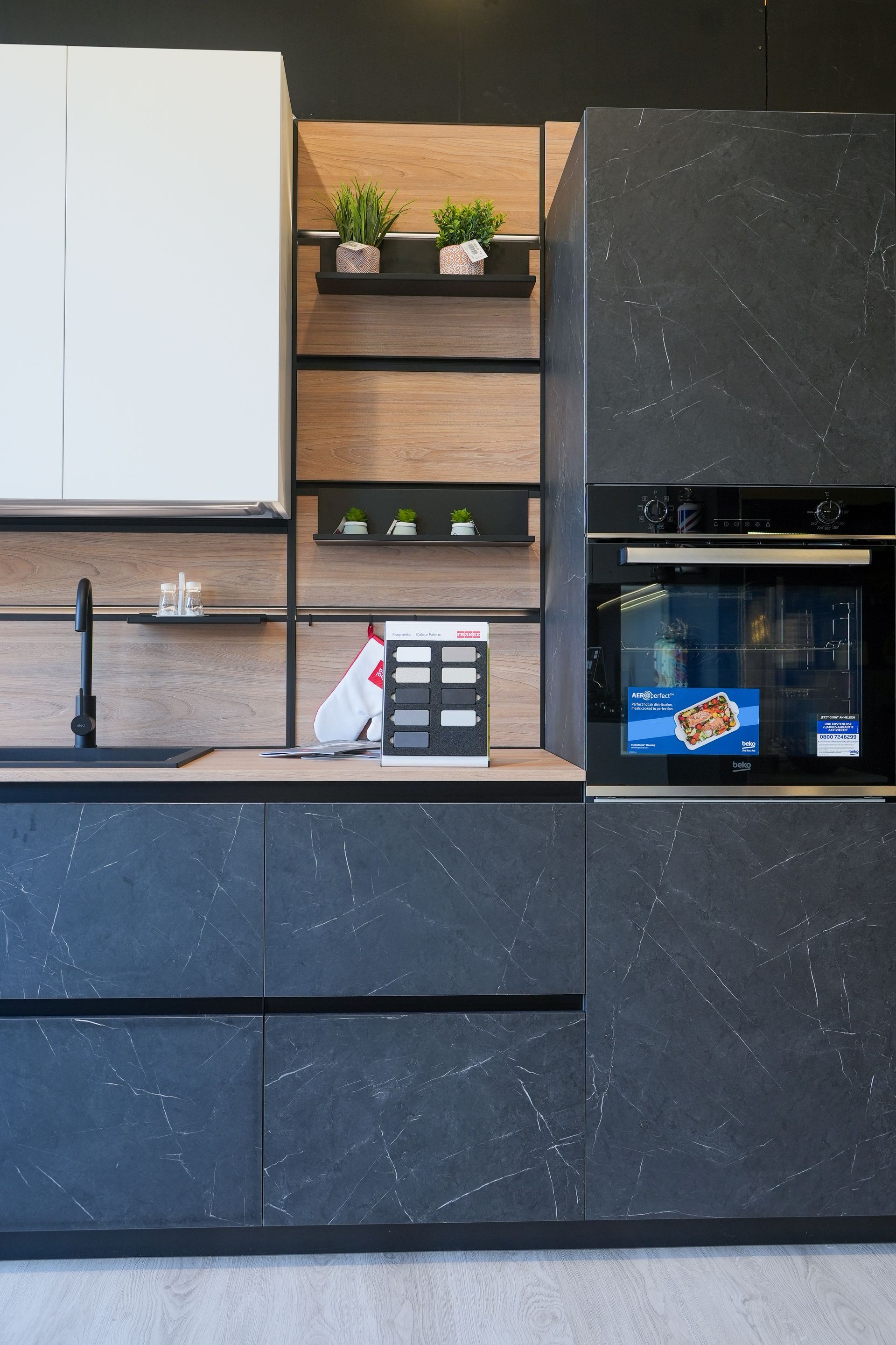 Una cucina con mobili neri e un frigorifero bianco