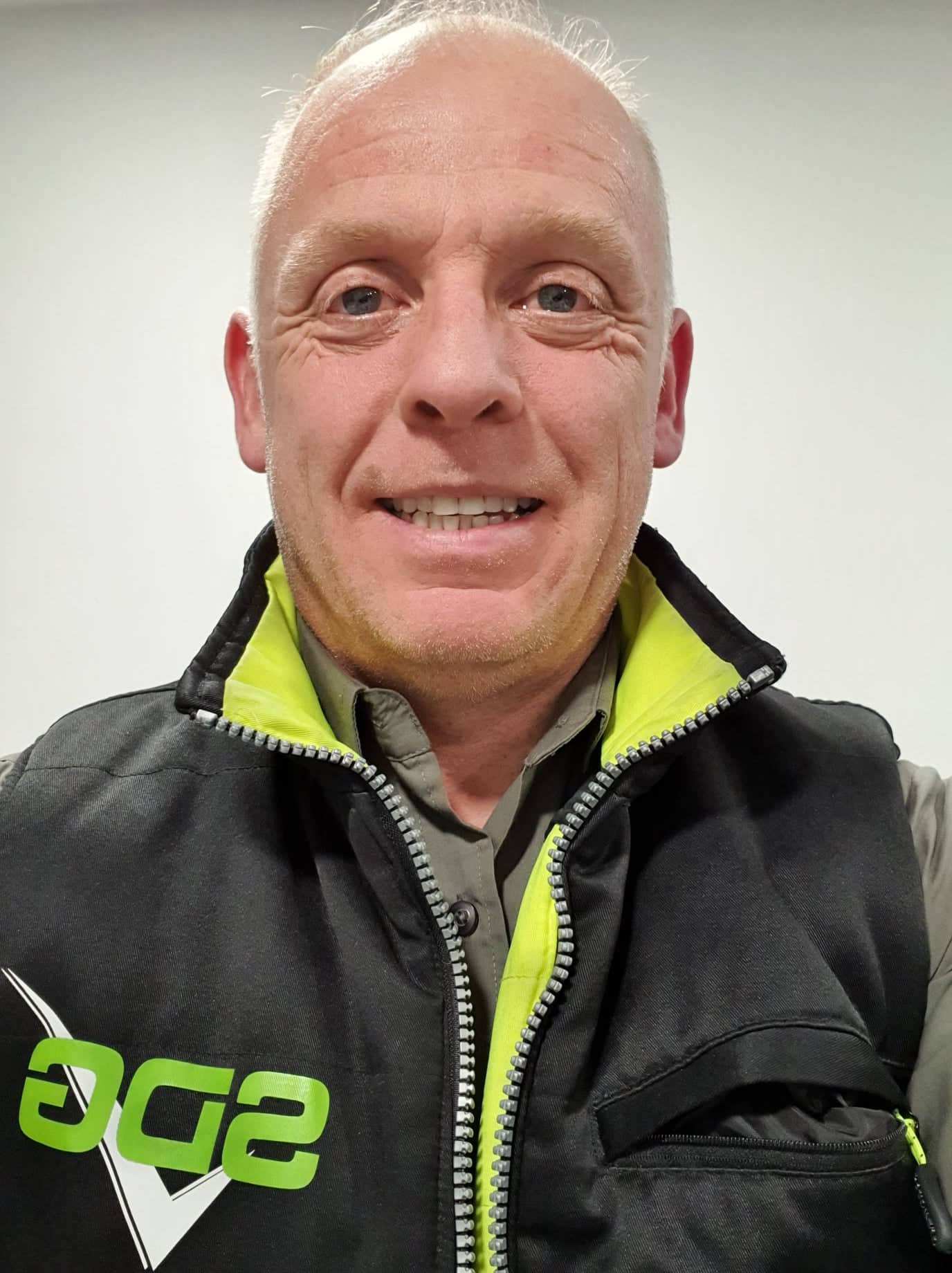 A man wearing a black vest with the word age on it