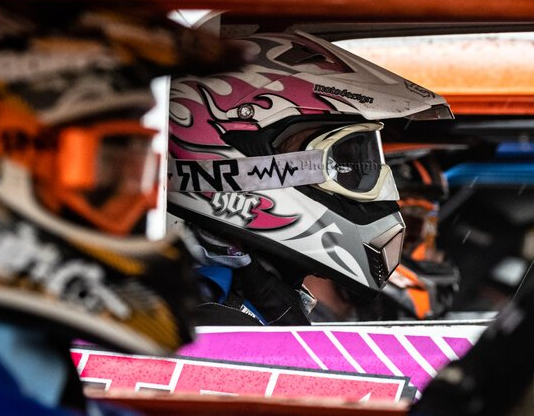 Three cars are racing on a dirt track.