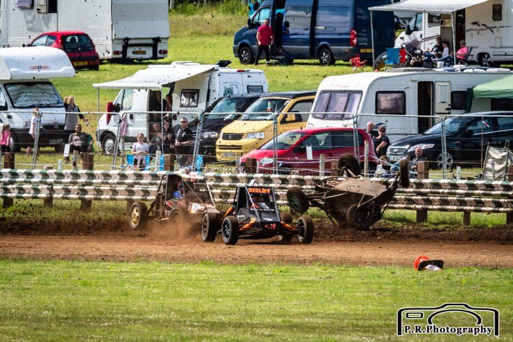 A group of cars are racing on a dirt track.
