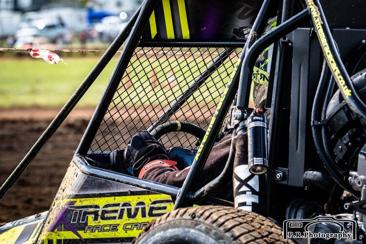 A person is driving a buggy on a dirt road.