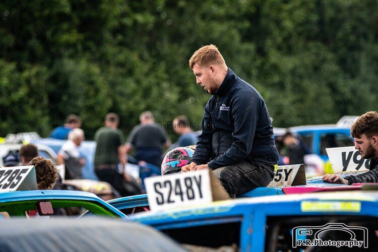 A man is sitting on top of a race car.