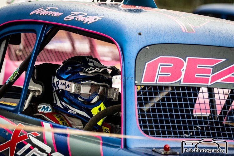 A person is sitting in the driver 's seat of a race car.