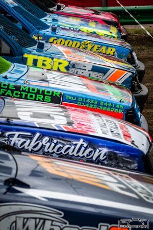 A row of race cars are parked next to each other.