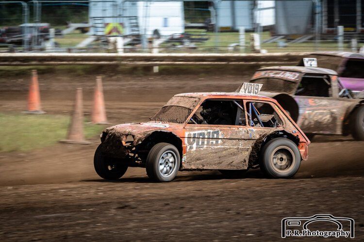 A dirt race car is driving down a dirt track.