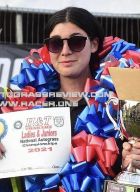 A woman is holding a trophy and a certificate that says h & t ladies & juniors national autograss championships 2021