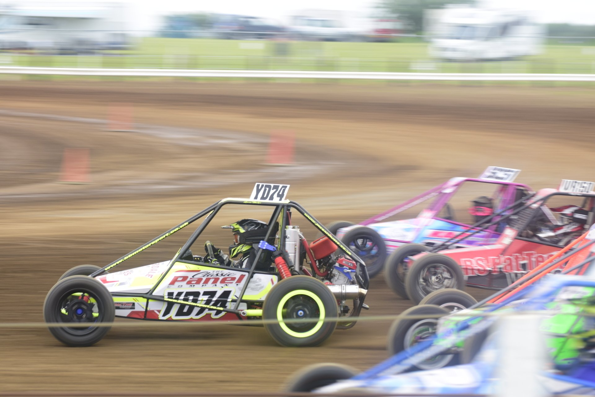 A group of buggies are racing on a dirt track.