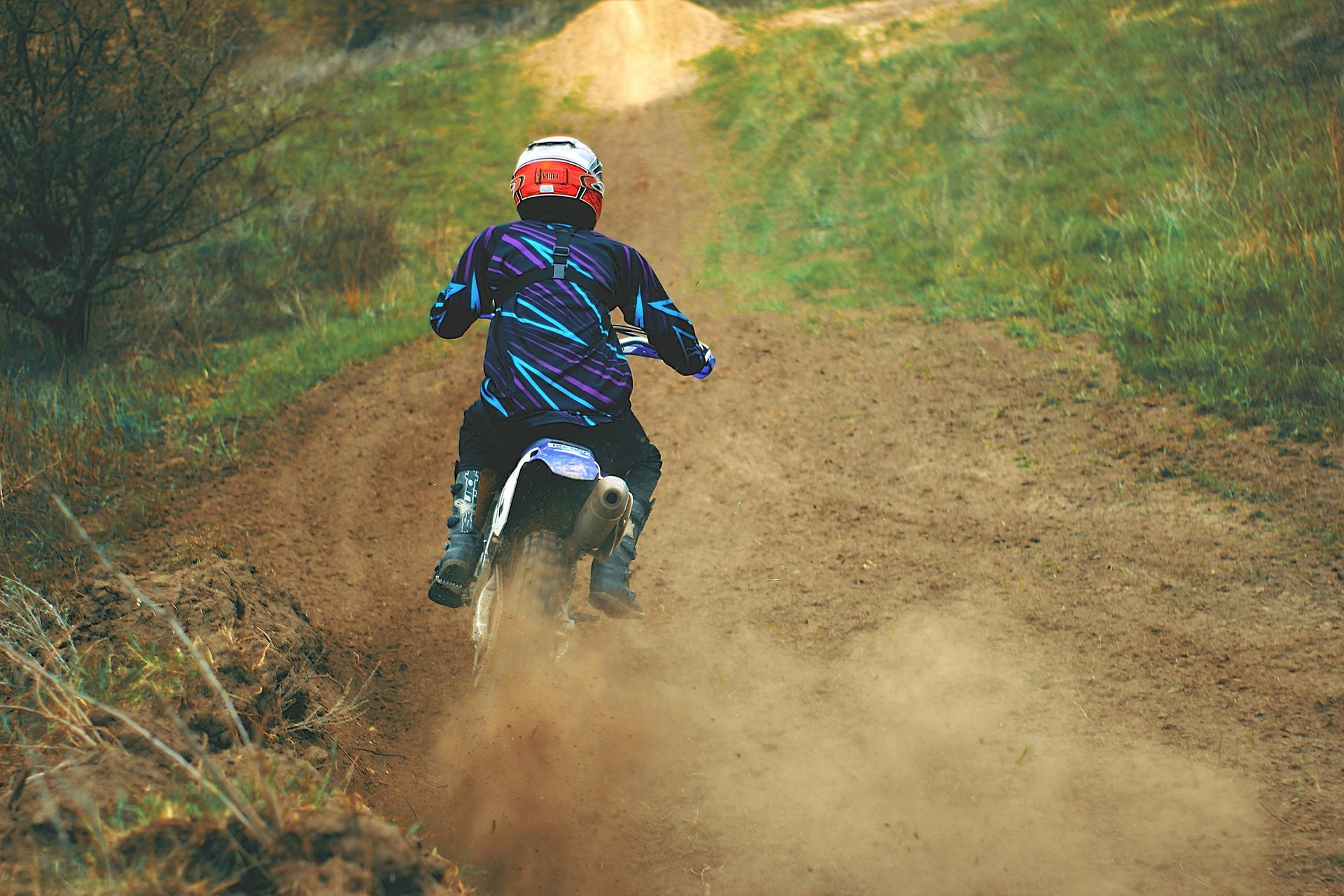 A person is riding a dirt bike on a dirt road.