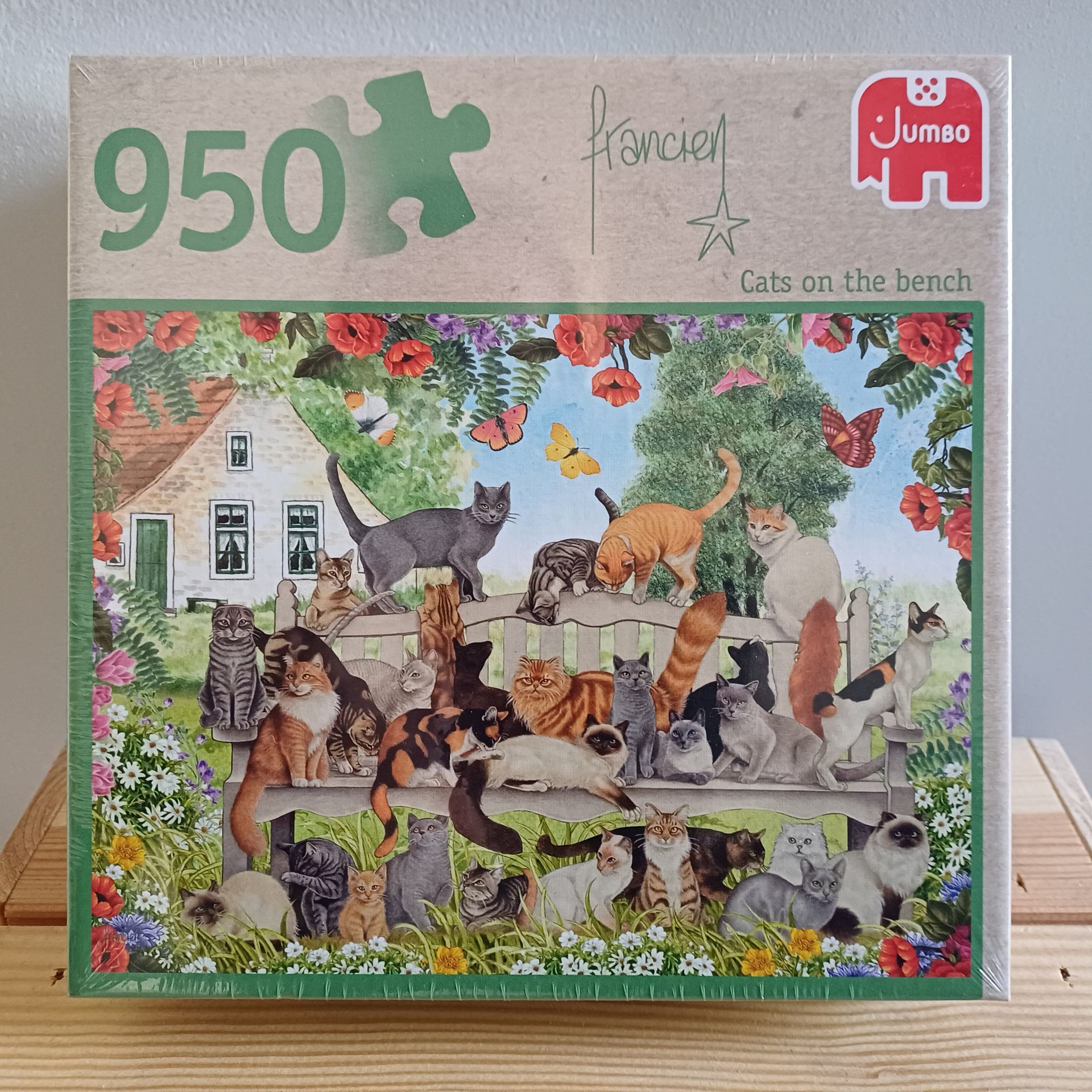 Puzzeldoos met 950 stukjes, waarop veel katten te zien zijn op een bankje voor een huis.