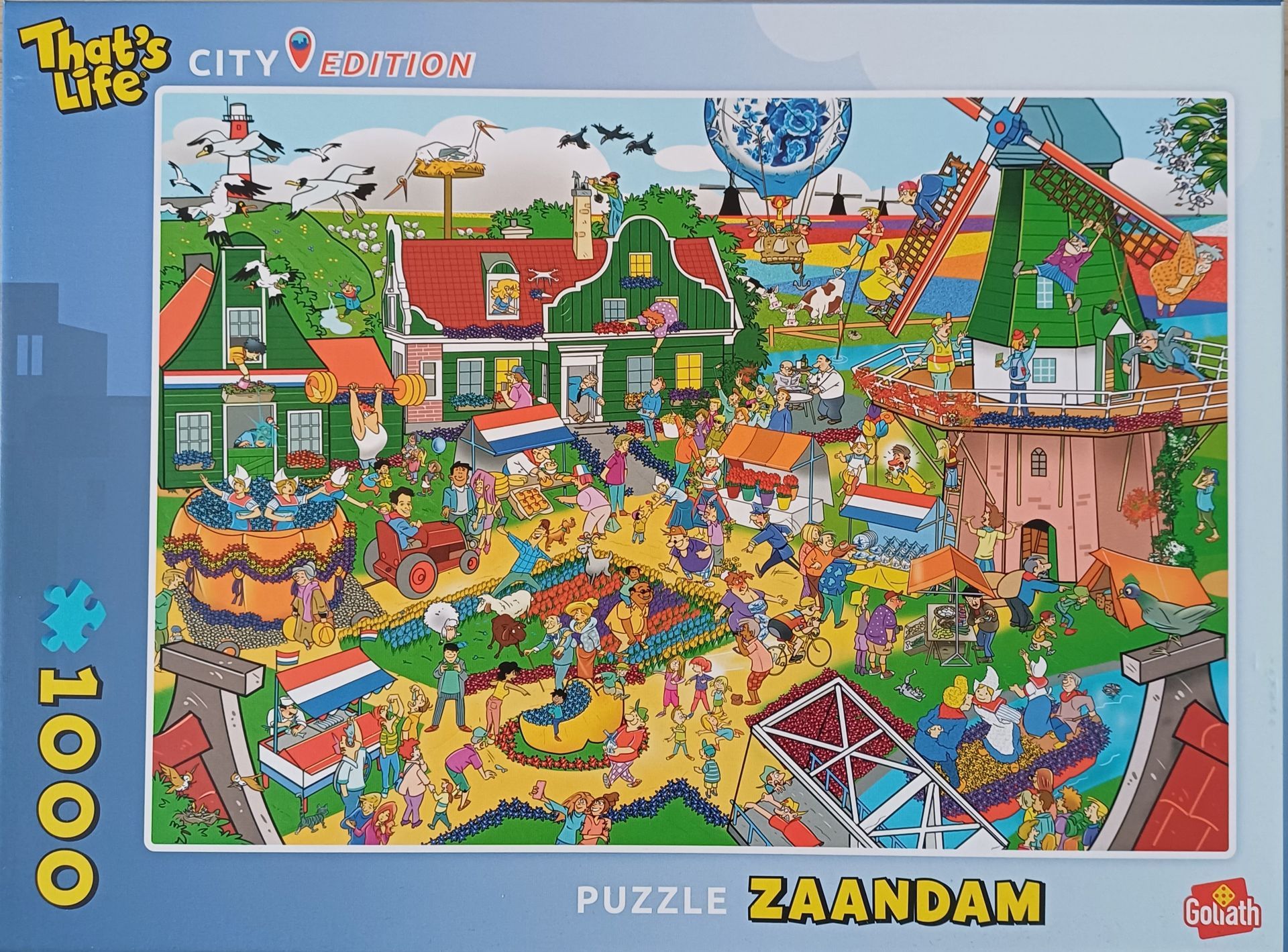 Puzzel van een levendige scène in Zaandam met windmolens, huizen en vele kleine figuren.