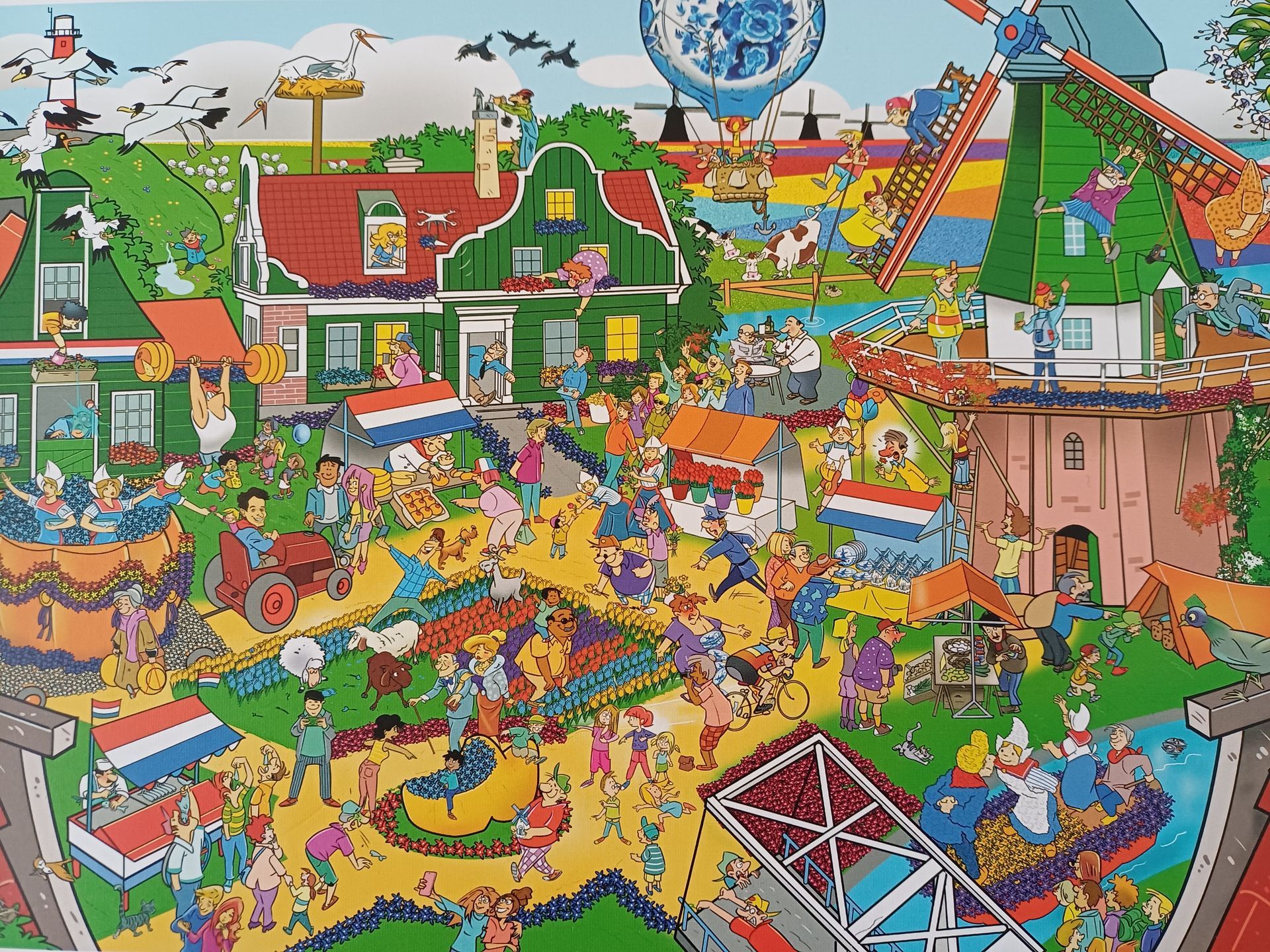 Puzzel van een levendige scène in Zaandam met windmolens, huizen en vele kleine figuren.