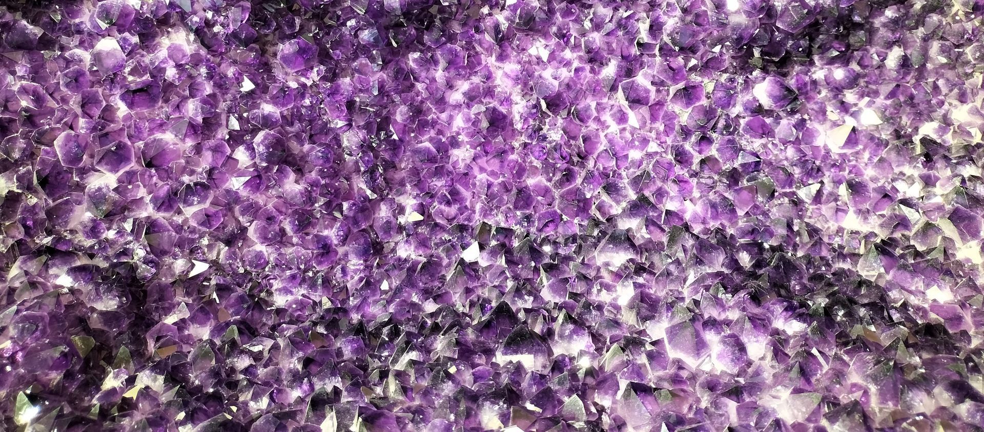 Close-up van een geode met veel kleine, paarse amethistkristallen.