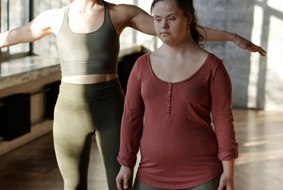 Two women are standing next to each other in a gym.