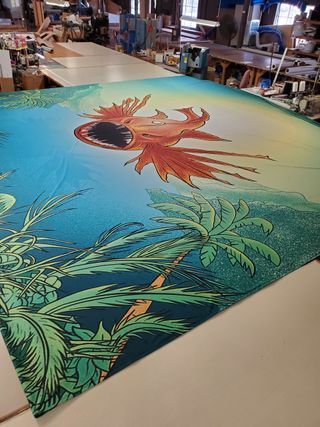 A large painting of a dragon is sitting on a table in a room