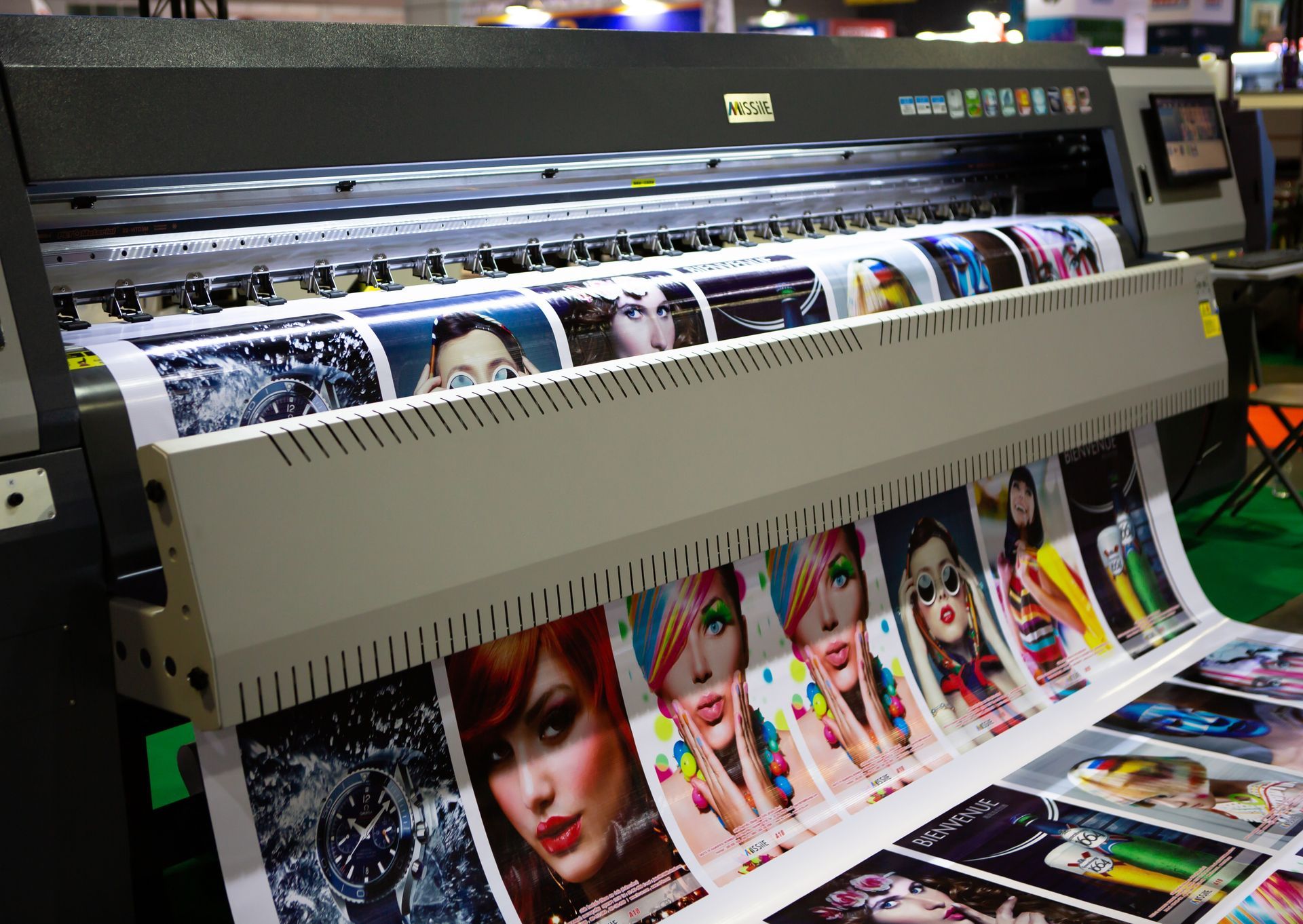 A large printer is printing a lot of pictures of women