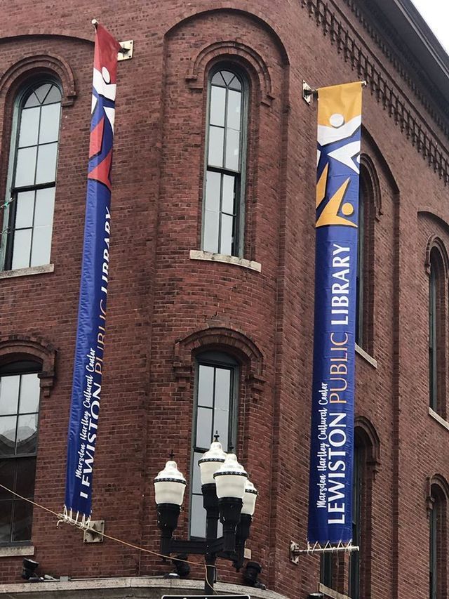 A brick building with a banner that says lewiston public library