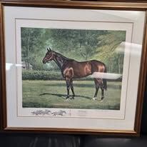 A framed painting of a brown horse in a grassy field, trees in the background.