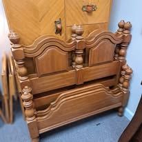 Wooden bed frame with carved headboard and footboard.