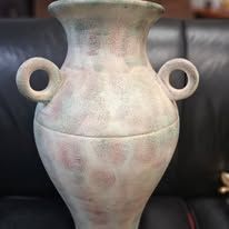 Large, antique vase with handles. Mottled pink and green hues on a white background.