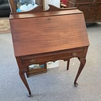 Wooden secretary desk with drawers and legs.