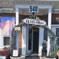 Entrance to a building, door with welcome sign, decorated with nautical elements; address 540 is visible.