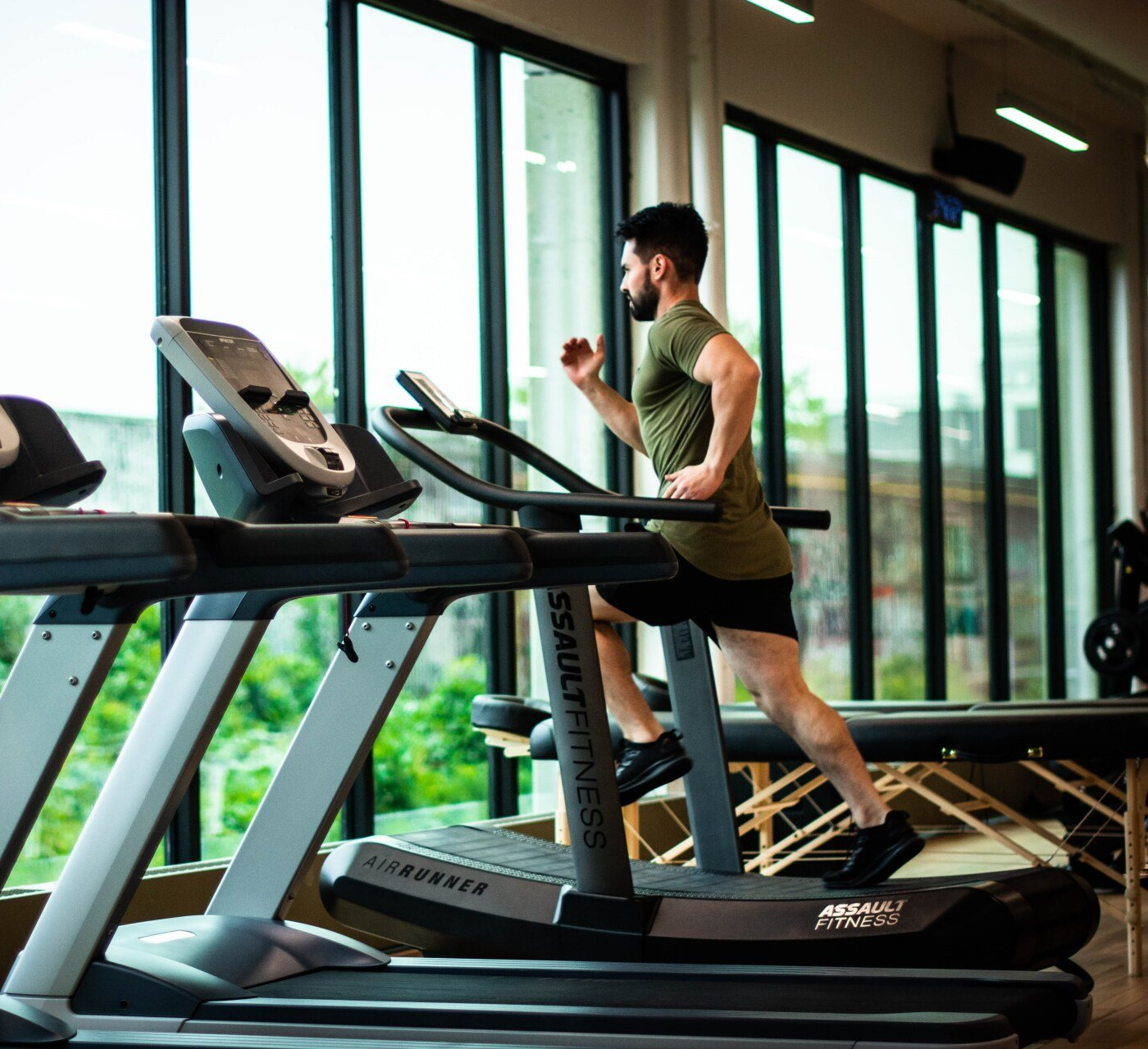 a man is running on a treadmill in a gym.