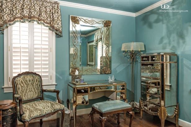 Bedroom vanity with mirrored furniture and blue walls.