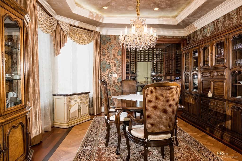 Elegant dining room with ornate wood furniture, chandelier, and patterned wallpaper.