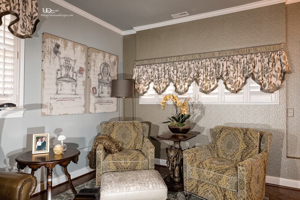 Cozy living room with floral patterned armchairs, matching window treatment, artwork, and side tables.